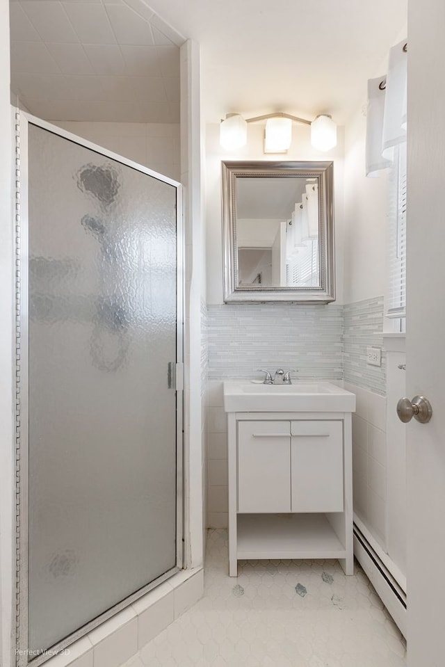 bathroom with vanity, a shower with shower door, tile walls, and a baseboard radiator