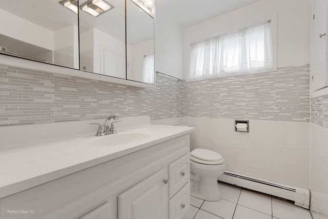 bathroom featuring vanity, a baseboard heating unit, tile patterned flooring, toilet, and tile walls