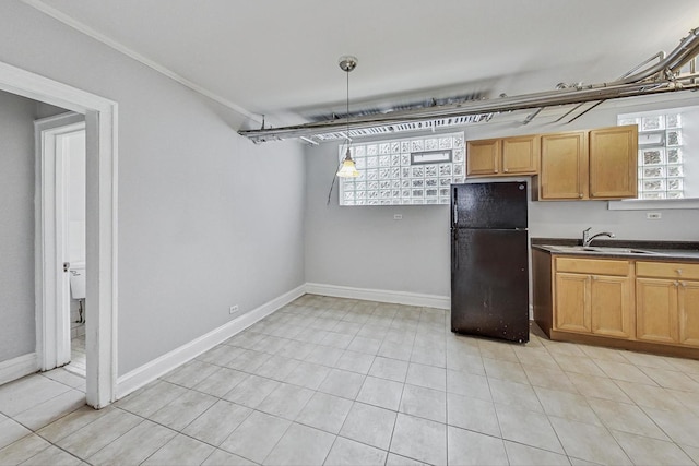 kitchen featuring pendant lighting, black fridge, crown molding, sink, and light tile patterned floors