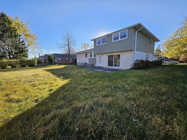 rear view of property featuring a patio area and a lawn