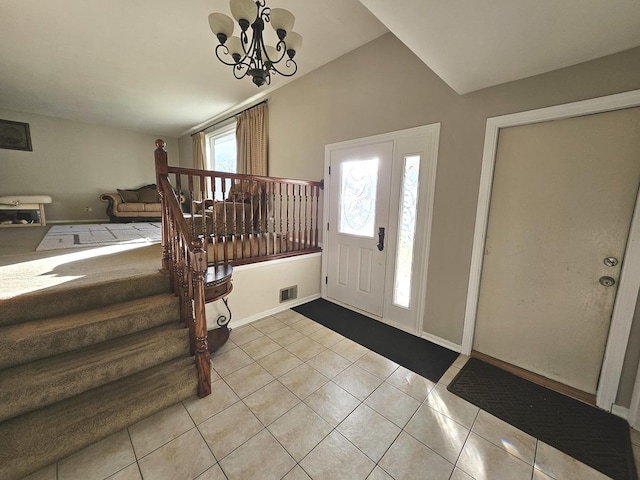 tiled foyer with vaulted ceiling and an inviting chandelier