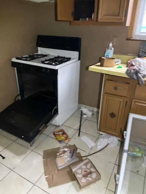 kitchen featuring light tile patterned floors and white gas range oven