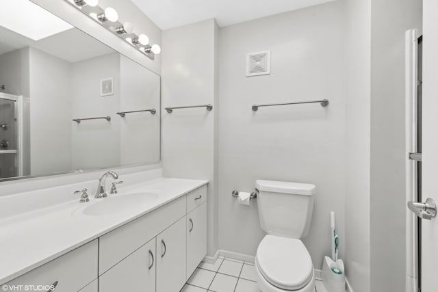 bathroom featuring tile patterned floors, vanity, a skylight, toilet, and walk in shower