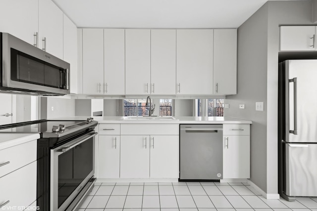 kitchen with appliances with stainless steel finishes, white cabinetry, and sink