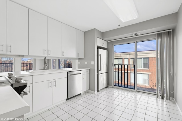 kitchen featuring a wealth of natural light, white cabinets, sink, and stainless steel appliances