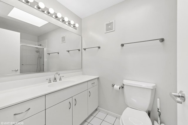 bathroom with a shower with shower door, toilet, vanity, and tile patterned flooring