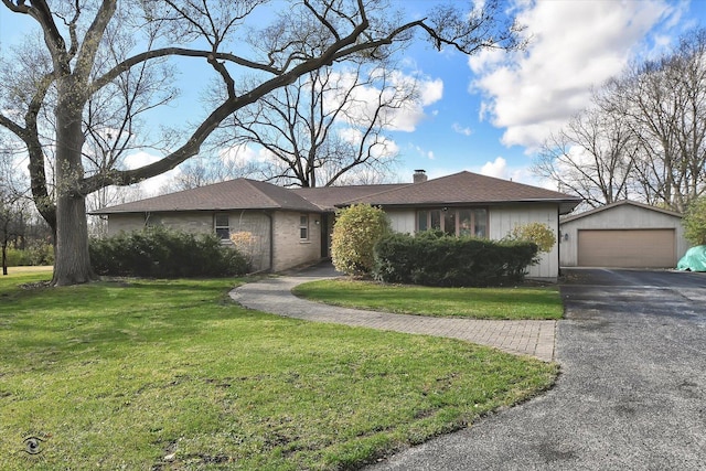 ranch-style home featuring an outbuilding, a front lawn, and a garage