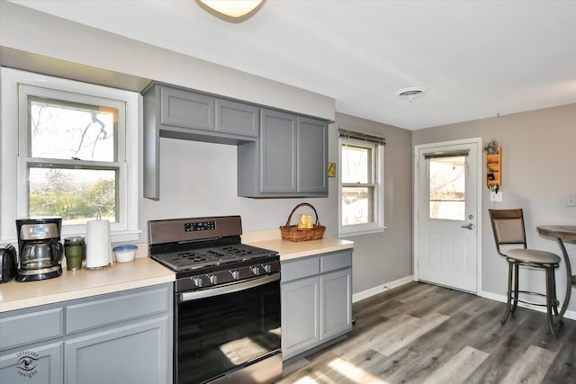 kitchen featuring gray cabinetry, black gas range, a healthy amount of sunlight, and dark wood-type flooring