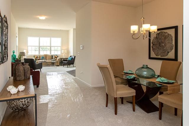 carpeted dining space with a notable chandelier