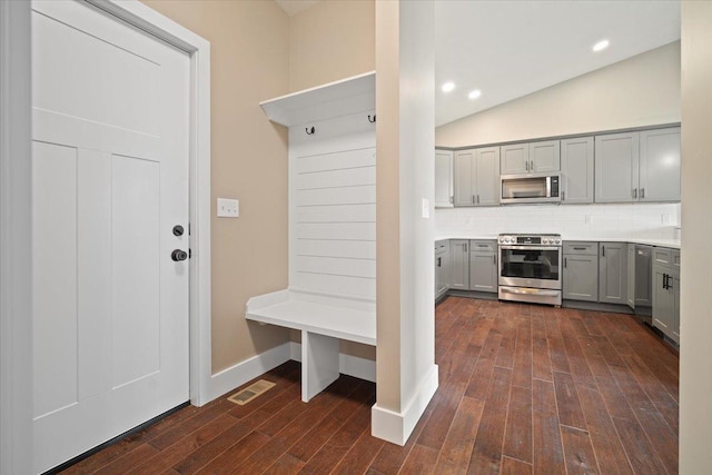 mudroom with baseboards, visible vents, dark wood-type flooring, vaulted ceiling, and recessed lighting