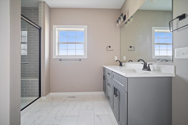 full bathroom with a healthy amount of sunlight, marble finish floor, baseboards, and a sink