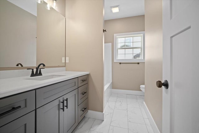 bathroom featuring marble finish floor, toilet, vanity, and baseboards