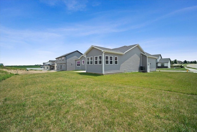 exterior space with central air condition unit and a yard