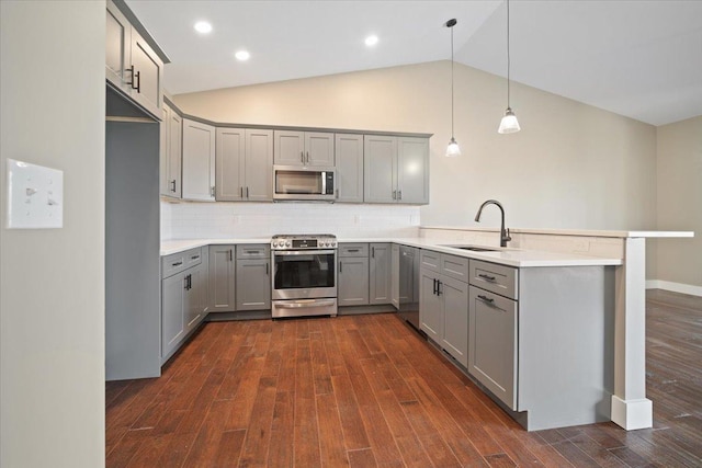 kitchen featuring stainless steel appliances, hanging light fixtures, a peninsula, and light countertops