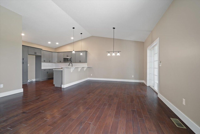 kitchen featuring pendant lighting, light countertops, stainless steel microwave, visible vents, and gray cabinetry