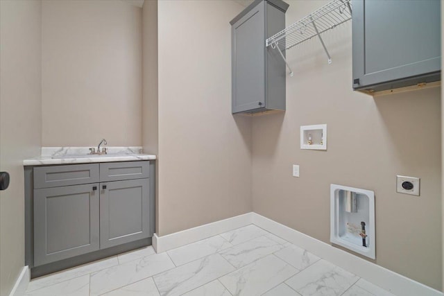 laundry room with cabinet space, baseboards, marble finish floor, electric dryer hookup, and a sink