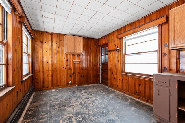 unfurnished room featuring a baseboard radiator and wooden walls