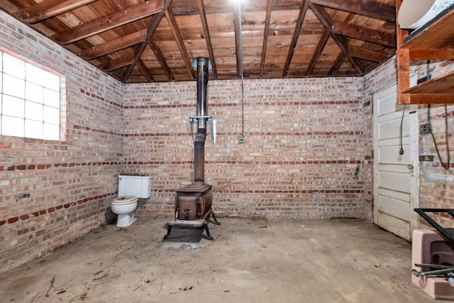 interior space with a wood stove, wooden ceiling, concrete flooring, and vaulted ceiling