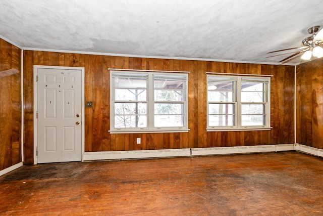 foyer with wooden walls, ceiling fan, and dark wood-type flooring