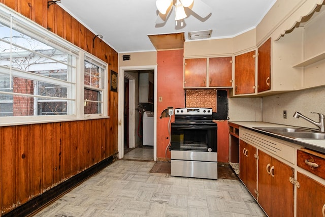 kitchen with ceiling fan, sink, washer / clothes dryer, stainless steel electric stove, and decorative backsplash