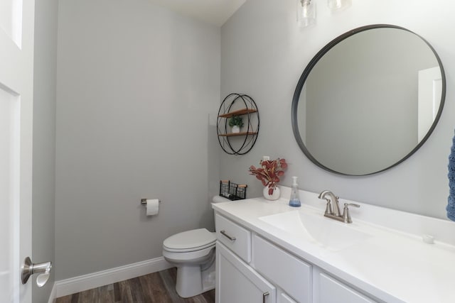 bathroom featuring wood-type flooring, vanity, and toilet