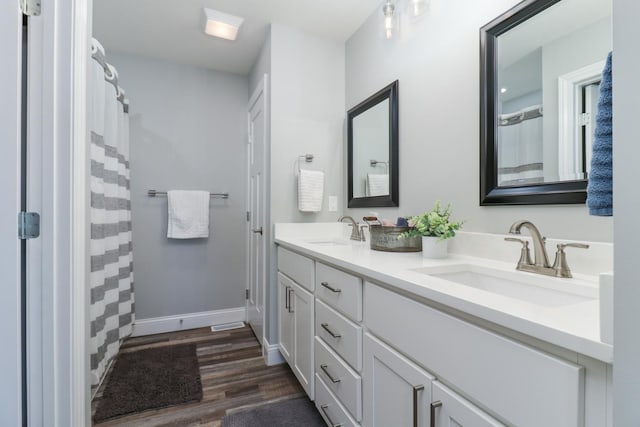 bathroom featuring wood-type flooring, vanity, and walk in shower