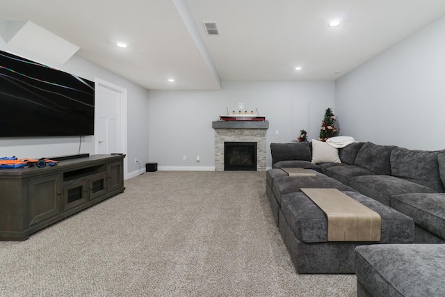 carpeted living room with a stone fireplace