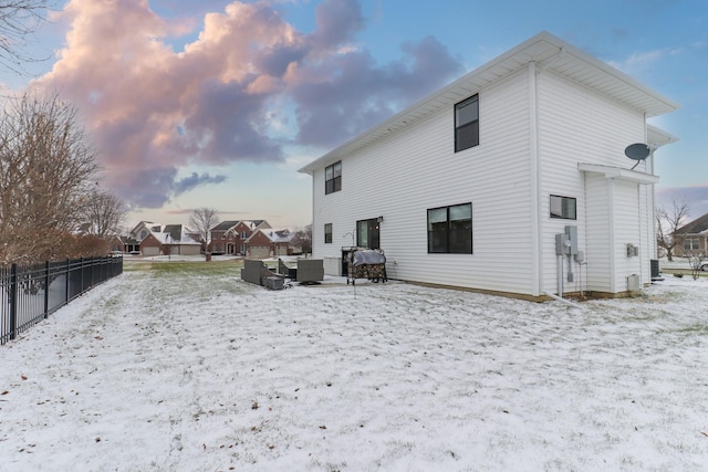 snow covered rear of property featuring central air condition unit and outdoor lounge area