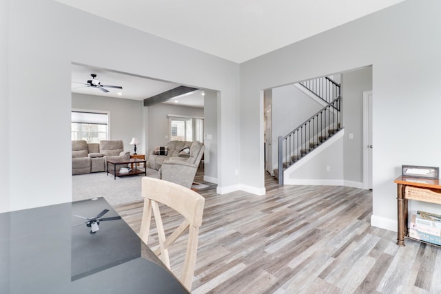 living room with ceiling fan, beamed ceiling, and light hardwood / wood-style floors