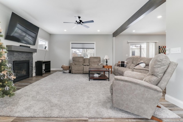 living room with a fireplace, hardwood / wood-style floors, ceiling fan, and beam ceiling