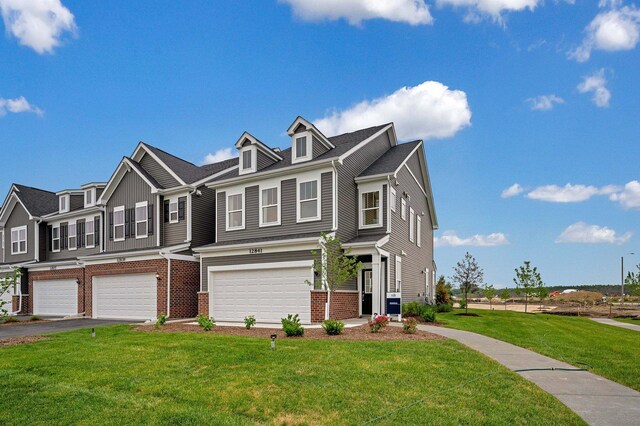 view of property featuring a garage and a front lawn