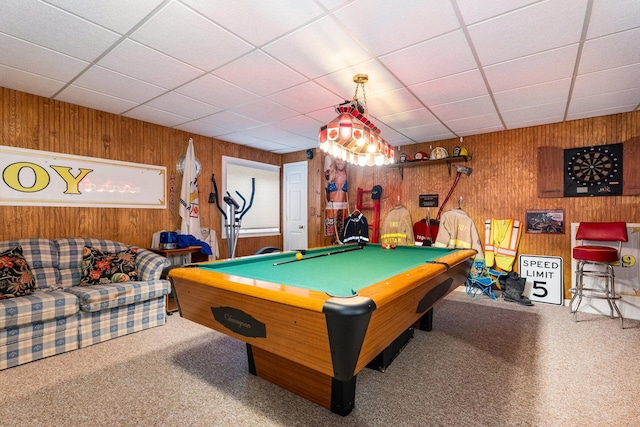 playroom featuring carpet floors, a drop ceiling, wooden walls, and pool table