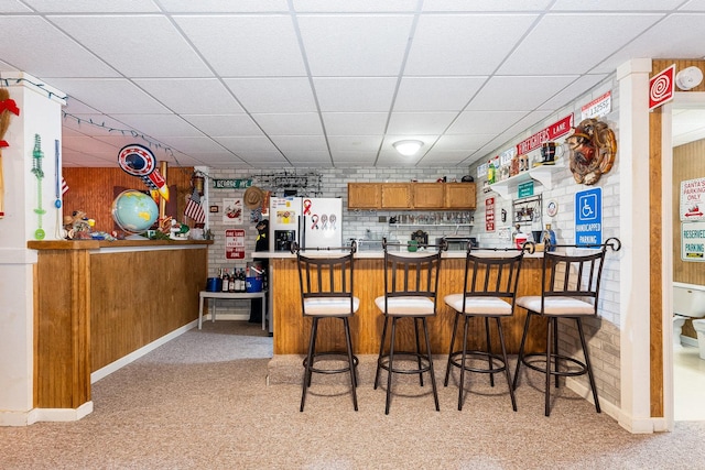 kitchen with white refrigerator with ice dispenser, a paneled ceiling, and kitchen peninsula