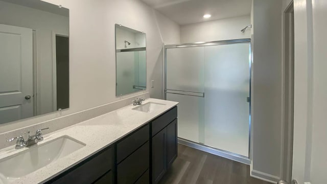 bathroom with vanity, an enclosed shower, and hardwood / wood-style flooring