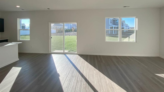 unfurnished living room with a wealth of natural light and dark wood-type flooring