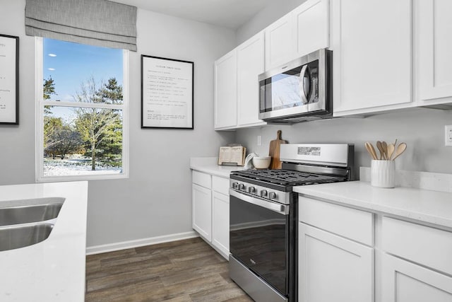 kitchen featuring dark wood-type flooring, white cabinets, and stainless steel appliances