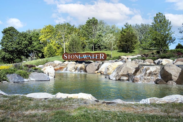 community / neighborhood sign featuring a water view