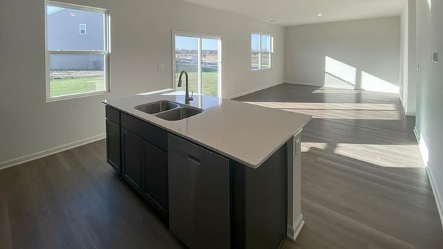 kitchen featuring stainless steel dishwasher, a wealth of natural light, sink, a center island with sink, and dark hardwood / wood-style floors