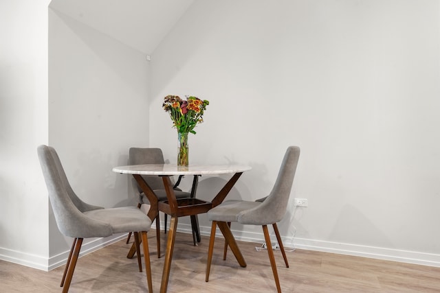 dining area featuring light hardwood / wood-style flooring and vaulted ceiling