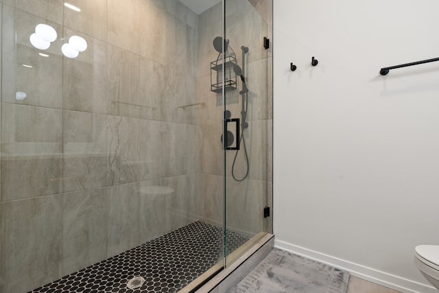 bathroom featuring toilet and an enclosed shower