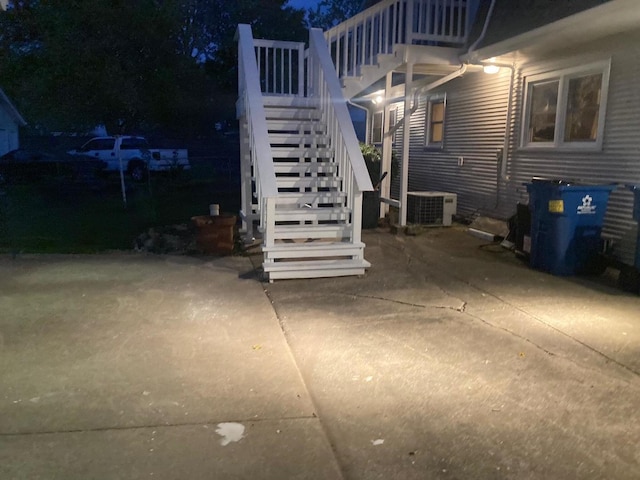 patio at twilight featuring cooling unit