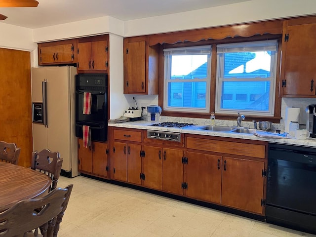 kitchen featuring dishwasher, white refrigerator with ice dispenser, backsplash, sink, and stainless steel gas cooktop