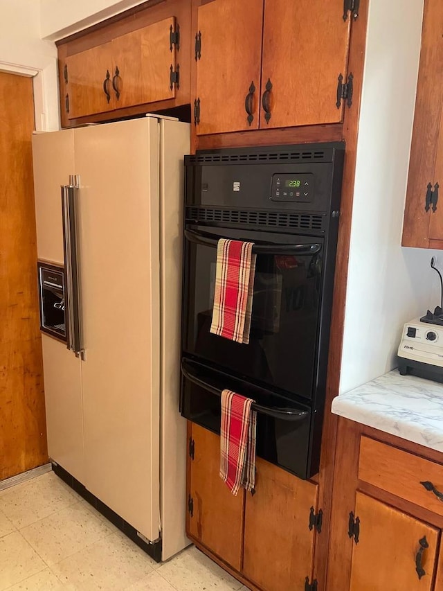 kitchen featuring white refrigerator with ice dispenser and double oven