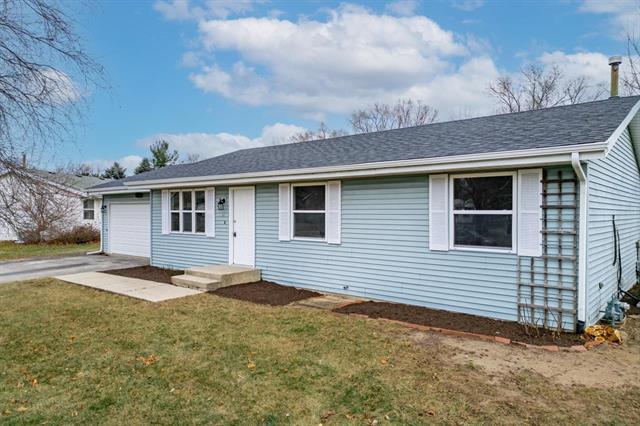 ranch-style house with a garage and a front lawn