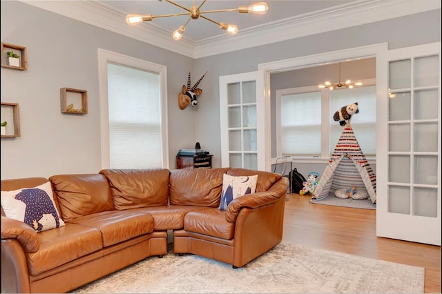 living room with wood-type flooring, a chandelier, french doors, and ornamental molding