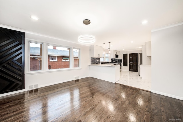 unfurnished living room with dark hardwood / wood-style floors, crown molding, and sink