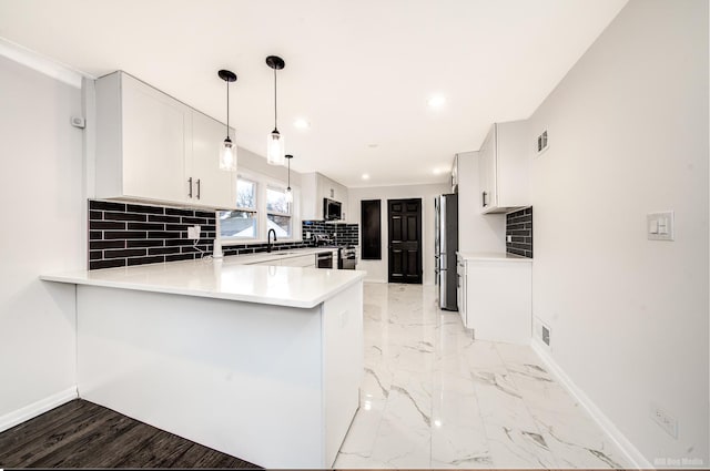 kitchen with white cabinets, backsplash, kitchen peninsula, and stainless steel appliances