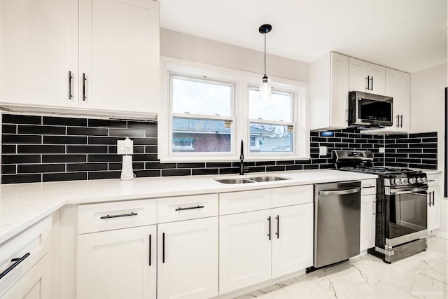 kitchen featuring white cabinetry, sink, stainless steel appliances, decorative light fixtures, and decorative backsplash