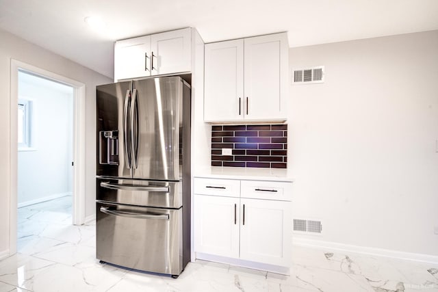 kitchen featuring backsplash, white cabinetry, and stainless steel refrigerator with ice dispenser