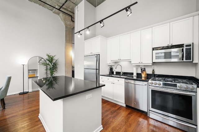 kitchen with white cabinets, sink, appliances with stainless steel finishes, and dark wood-type flooring